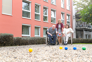 Bewohner spielen gemeinsam im Garten Spiele 