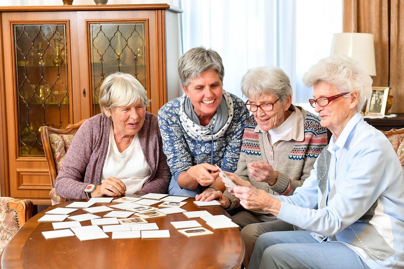 der Soziale Dienst spielt Kartenspiele mit den Bewohnern am Tisch 