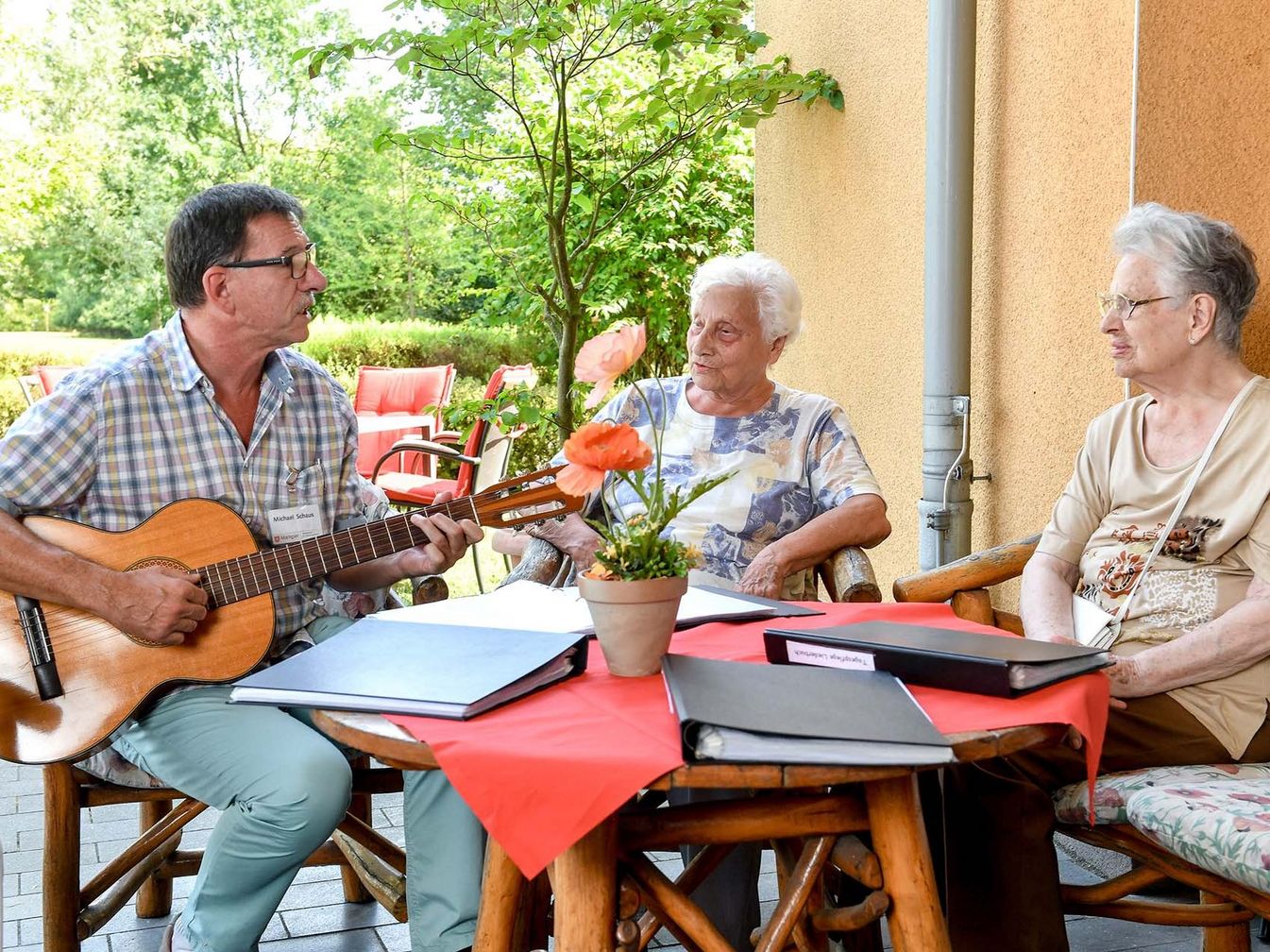 Sozialer Dienst spielt mit der Gitarre Lieder für die Bewohner 