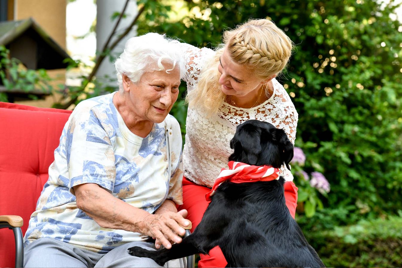 Begleiterin des sozialen Dienstes besucht Bewohnerin mit einem Hund  
